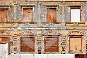 Boarded up derelict building facade peeling paint