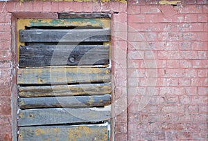 Boarded up window on an old brick wall