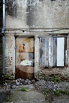 Boarded up window and rusty door