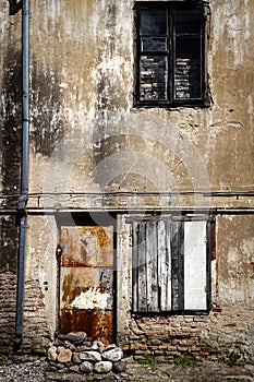 Boarded up window and rusty door