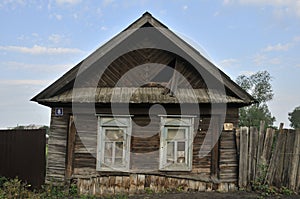 Boarded up windows on the old wooden wall of the house. Carving adorns the old window. The walls of the house from the old logs