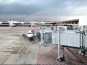 Boarding Bridge on the tarmac of an airport. Jet aircraft docked at the gate.