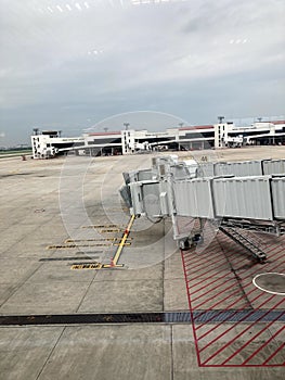 Boarding Bridge on the tarmac of an airport. Jet aircraft docked at the gate.