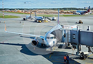 Boarding passengers on a plane using a jet bridge at Sheremetyevo airport, Moscow, in the background a runway under construction