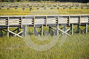 A boardwalk with rails above a marsh