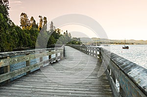 Boardwalk on the shore of a beautiful bay at sunset