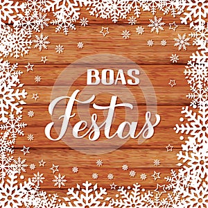 Boas Festas calligraphy on wood background with snowflakes. Happy Holidays hand lettering in Portuguese. Christmas typography