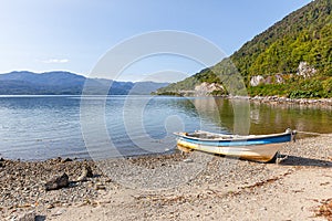 Boat anchored on the beach of the fjord of Puyuhuapi, Patagonia, Chile. Pacific Ocean