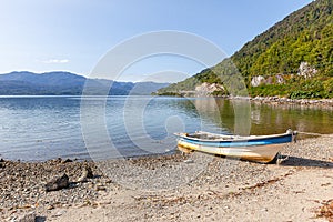 Boat anchored on the beach of the fjord of Puyuhuapi, Patagonia, Chile. Pacific Ocean photo