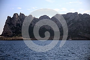 Boat anchored in the shade under the rocky outcrop, Parc National des Calanques, Marseille, France