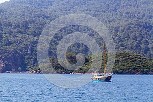 Boat on the background of mountains overgrown with forest