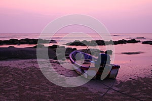 A boat on the beach at colorful sunset