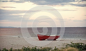 Boat on the beach. Fishermens boat at seacoast, on sand on cloudy day with sea on background. Fishing boat on beach in