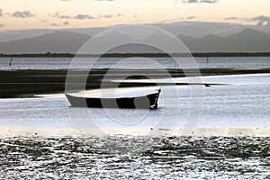 A boat on the beach and montains photo