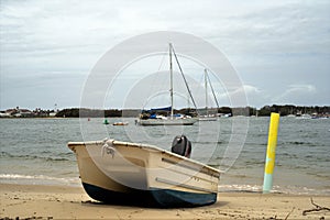 Boat on beach sand under cloudy sky