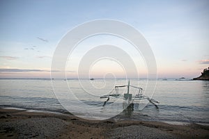 boat on a beach at sunset in Asia