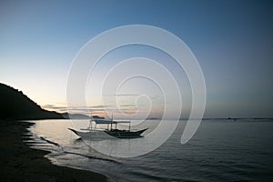 boat on a beach at sunset in Asia