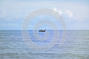 Boat in blue sea with clouds sky background in Thailand.