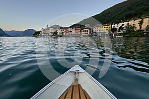A boat bobs on the waves of a lake in Switzerland, approaching the coastline photo