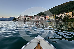 A boat bobs on the waves of a lake in Switzerland, approaching the coastline photo