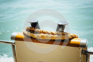 Boat bollard with rope against water background