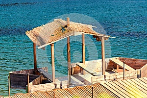 Boat bridge with wooden boat and thatched roof.