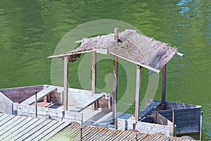 Boat bridge with wooden boat and thatched roof.