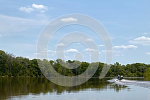 Boat on calm scenic river on a bright sunny day