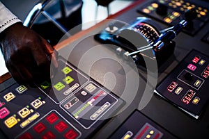 Boat captain hands navigating and moving instruments in the cockpit