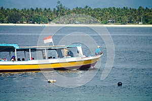 Boat carries passengers by sea in the background of a tropical island. Gili Island. Indonesia