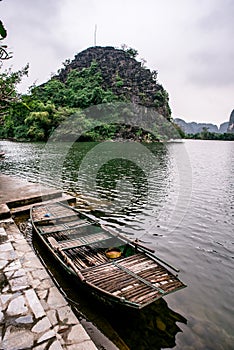 Boat cave tour in Trang An Scenic Landscape formed by karst towers and plants along the river (UNESCO World Heritage Site). It's