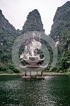 Boat cave tour in Trang An Scenic Landscape formed by karst towers and plants along the river (UNESCO World Heritage Site). It's