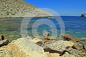 Boat in clear blue water of Cala Castell photo