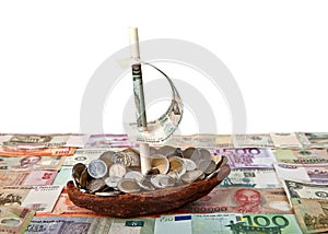 Boat with coins on background of banknotes of different countries