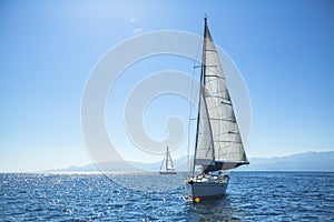 Boat competitor of sailing regatta in clear sunny weather.