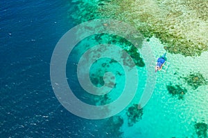 Boat on a coral reef. Sea surface with an atoll, coral reefs. Sea shoal and depth