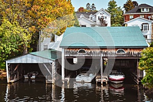 Boat cottage dock. Lake Ontario in autumn. Colorful vivid trees. Canada, United States of America