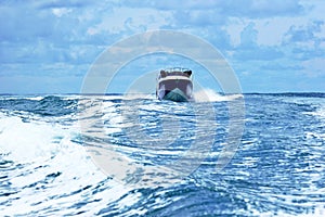 Boat crossin the sea at high speed. Waves shacking the waters