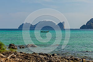 Boat crossing bay during sunny day at the tropical beach in Thailand. Asia. Blue sky