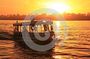 Ein Boot reisekosten ein Fluss auf der Sonnenuntergang 