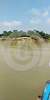 The boat is cruising on the river in the village