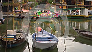 Boat decorated with paper whizzers moored to embankment