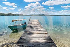 Boat at a dock at lake Itza with turquoise water, El Remate, Peten, Guatemala