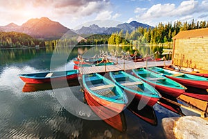 Boat on the dock surrounded by mountains at sunset.