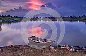 Boat docked on river in beatiful twilight sky