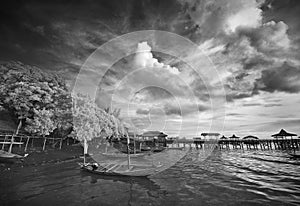 Boat docking at beach under cloudy sky