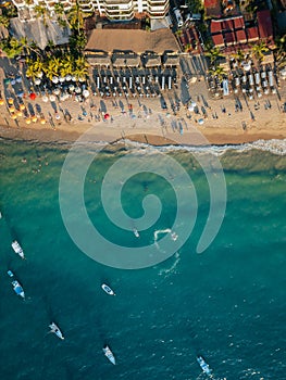 Boat doing circles in the ocean below near popular beach in Puerto Vallarta Mexico