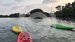 Boat drag empty green,red and yellow kayak by rope floating on water prepared for tourist kayaking travel adventure.Summer vacatio