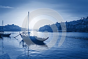 Boat on Duoro river in Porto, Portugal toned in trendy classic blue - color of the year 2020 concept