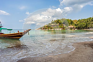 Boat on empty calm sandy tropical Sairee beach in the morning on Koh Tao island